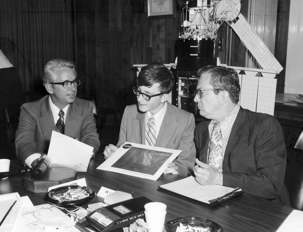 Youngstown, Ohio high school student, W. Brian Dunlap (center), discusses with Dr. Robert Head (right), and Henry Floyd, both of the Marshall Space Flight Center (MSFC), his experiment to be performed aboard the Skylab the following year. His experiment, “Wave Motion Trough A Liquid in Zero Gravity” used a container attached to the end of a leaf spring which was oscillated at specific rates using two thickness differentiated types of liquids. Dunlap was among 25 winners of a contest in which some 3,500 high school students proposed experiments for the following year’s Skylab mission. The nationwide scientific competition was sponsored by the National Science Teachers Association and the National Aeronautics and Space Administration (NASA). The winning students, along with their parents and sponsor teachers, visited MSFC where they met with scientists and engineers, participated in design reviews for their experiments, and toured MSFC facilities. Of the 25 students, 6 did not see their experiments conducted on Skylab because the experiments were not compatible with Skylab hardware and timelines. Of the 19 remaining, 11 experiments required the manufacture of additional equipment. The equipment for the experiments was manufactured at MSFC.