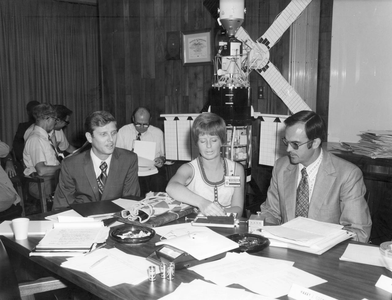Miss Cheryl Peltz, high school student from Littleton, Colorado, discusses her “Cytoplasmic Streaming in Zero Gravity” experiment with Ed Armstrong (left) of the NASA Manned Spacecraft Center, and her advisor Charles Cothran (right) of the NASA Marshall Space Flight Center (MSFC).  She was one of the 25 winners of a contest in which some 3,500 high school students proposed experiments for the following year’s Skylab Mission. Of the 25 students, 6 did not see their experiments conducted on Skylab because the experiments were not compatible with Skylab hardware and timelines.  Of the 19 remaining, 11 experiments required the manufacture of equipment, of which Miss Peltz’s was one.