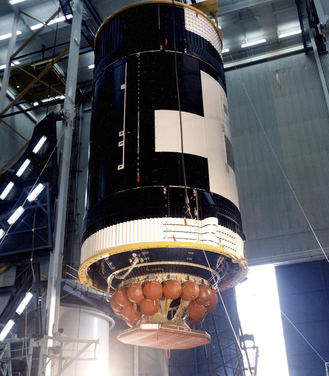 This photograph shows the Skylab Orbital Workshop (OWS) assembled, with its Thruster Attitude Control System (TACS) and radiator, ready for placing on the transporter. Twenty-two titanium spheres above the radiator housed the nitrogen required for operation of the TACS. At one end of the OWS, the TACS provided short-term control of the attitude of the Skylab. 
