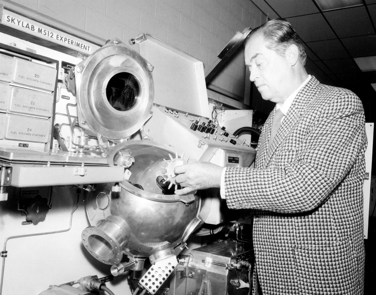 Hans F. Wuenscher, assistant director for Advanced Space Projects Engineering Laboratory at Marshall Space Flight Center (MSFC), examined the facility to be used by Skylab astronauts in performing a number of experiments in material science and manufacturing in space.  The equipment shown here is a duplicate of the M512 Experiment hardware flown in the Multiple Docking Adapter section of the Sky lab.  This equipment, itself an experiment, was be used for conducting 5 other experiments in the round vacuum chamber.  Inside was a cavity which held the M518 Multipurpose Electric Furnace, a facility which was used for conducting other experiments.  In all, a total of 17 experiments were conducted using this facility and furnace.