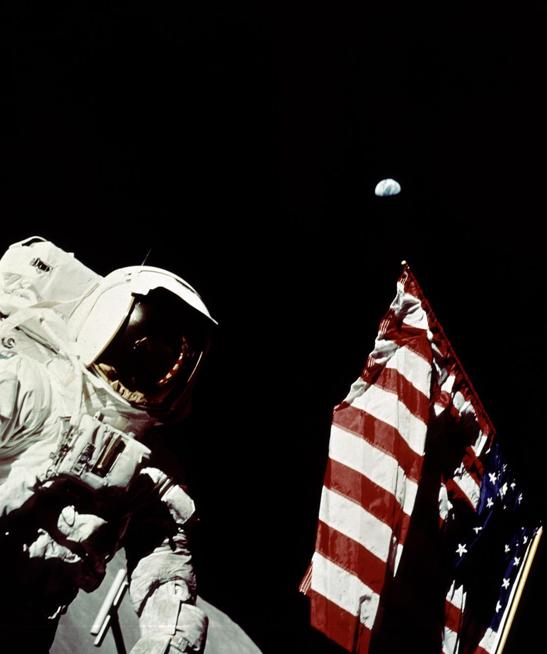 In this Apollo 17 onboard photo, Mission Commander Eugene A. Cernan adjusts the U.S. flag deployed upon the Moon. The seventh and last manned lunar landing and return to Earth mission, the Apollo 17, carrying a crew of three astronauts: Cernan; Lunar Module pilot Harrison H. Schmitt; and Command Module pilot Ronald E. Evans, lifted off on December 7, 1972 from the Kennedy Space Flight Center (KSC). Scientific objectives of the Apollo 17 mission included geological surveying and sampling of materials and surface features in a preselected area of the Taurus-Littrow region, deploying and activating surface experiments, and conducting in-flight experiments and photographic tasks during lunar orbit and transearth coast (TEC). These objectives included: Deployed experiments such as the Apollo lunar surface experiment package (ALSEP) with a Heat Flow experiment, Lunar seismic profiling (LSP), Lunar surface gravimeter (LSG), Lunar atmospheric composition experiment (LACE) and Lunar ejecta and meteorites (LEAM). The mission also included Lunar Sampling and Lunar orbital experiments. Biomedical experiments included the Biostack II Experiment and the BIOCORE experiment. The mission marked the longest Apollo mission, 504 hours, and the longest lunar surface stay time, 75 hours, which allowed the astronauts to conduct an extensive geological investigation. They collected 257 pounds (117 kilograms) of lunar samples with the use of the Marshall Space Flight Center developed LRV. The mission ended on December 19, 1972