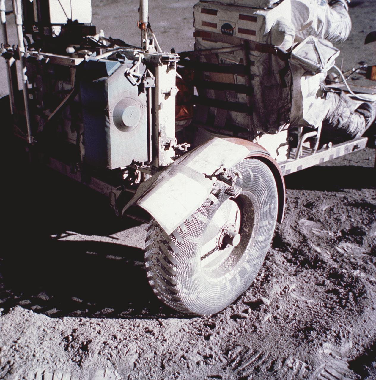 This photograph taken during the Apollo 17 mission (the last mission of the Apollo Program), depicts stiff plasticized maps being taped together and fastened by clamps to patch a broken fender of the Lunar Roving Vehicle (LRV). Powered by battery, the lightweight electric car greatly increased the range of mobility and productivity on the scientific traverses for astronauts. It weighed 462 pounds (77 pounds on the Moon) and could carry two suited astronauts, their gear and cameras, and several hundred pounds of bagged samples. The LRV's mobility was quite high. It could climb and descend slopes of about 25 degrees. The LRV was designed and developed by the Marshall Space Flight Center and built by the Boeing Company. 