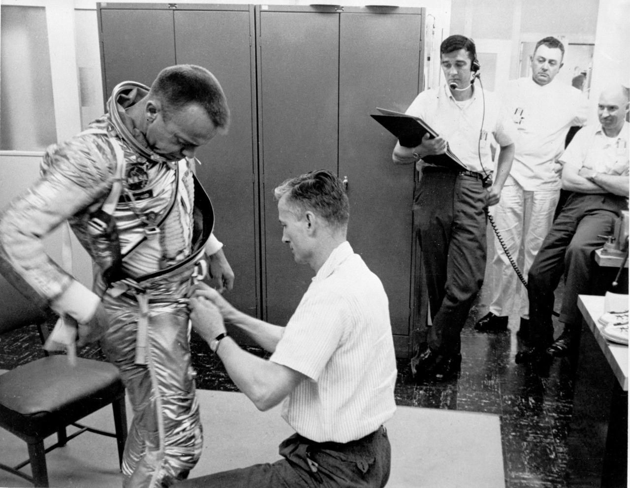 KENNEDY SPACE CENTER, FLA. - Astronaut Alan B. Shepard is being assisted by a technician in getting into his space suit at 2:45 a.m. this morning, beginning the long countdown of the scheduled launch of the Mercury Redstone. After Astronaut Shepard is suited up, he will travel by van to the Redstone Gantry on Pad 5 and be placed into the Mercury Capsule, called Freedom 7, on top of the Redstone booster rocket.  Astronaut Shepard will pilot the first U.S. manned sub-orbital space flight of the Manned Mercury Program.