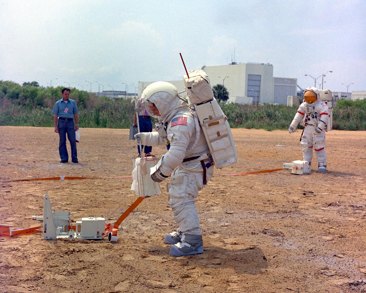 KENNEDY SPACE CENTER, FLA. - Apollo 15 Lunar Module Pilot James B. Irwin deploys the Suprathermal Ion Detector Experiment during a training exercise at the Kennedy Space Center. Mission Commander David R. Scott is working in the background on the simulated lunar surface, a replica of the Moon's Hadley-Apennine region. They will be launched to the Moon no earlier than July 26, 1971, along with Command Module Pilot Alfred M. Worden.