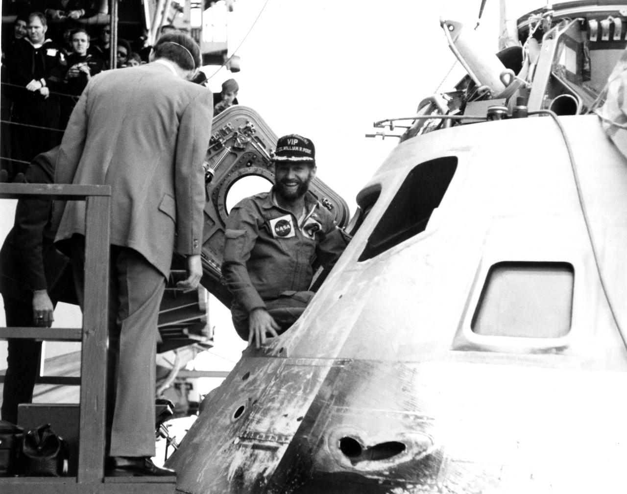 SKYLAB 4 PACIFIC RECOVERY AREA -- A smiling William R. Pogue pauses in hatchway of Skylab 4 command module during recovery activities today aboard the USS New Orleans at the completion of man's longest space journey to date.  Pogue splashed down with astronauts Gerald P. Carr and Dr. Edward G. Gibson at 11:17 a.m. EDT Feb. 8, 1974, 84 days after the trio was launched by a Saturn IB rocket from Kennedy Space Center.  Circling the globe 1, 214 times aboard the sophisticated Skklab space station during the nearly three-month flight, the astronauts demonstrated man's ability to live and work in space for extended periods.