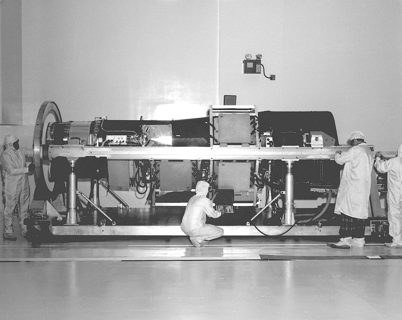 This photograph is of the High Energy Astronomy Observatory (HEAO)-2 telescope being checked by engineers in the X-Ray Calibration Facility at the Marshall Space Flight Center (MSFC). The MSFC was heavily engaged in the technical and scientific aspects, testing and calibration, of the HEAO-2 telescope. The HEAO-2 was the first imaging and largest x-ray telescope built to date. The X-Ray Calibration Facility was built in 1976 for testing MSFC's HEAO-2. The facility is the world's largest, most advanced laboratory for simulating x-ray emissions from distant celestial objects. It produced a space-like environment in which components related to x-ray telescope imaging are tested and the quality of their performance in space is predicted. The original facility contained a 1,000-foot long by 3-foot diameter vacuum tube (for the x-ray path) cornecting an x-ray generator and an instrument test chamber. Recently, the facility was upgraded to evaluate the optical elements of NASA's Hubble Space Telescope, Chandra X-Ray Observatory and Compton Gamma-Ray Observatory. 