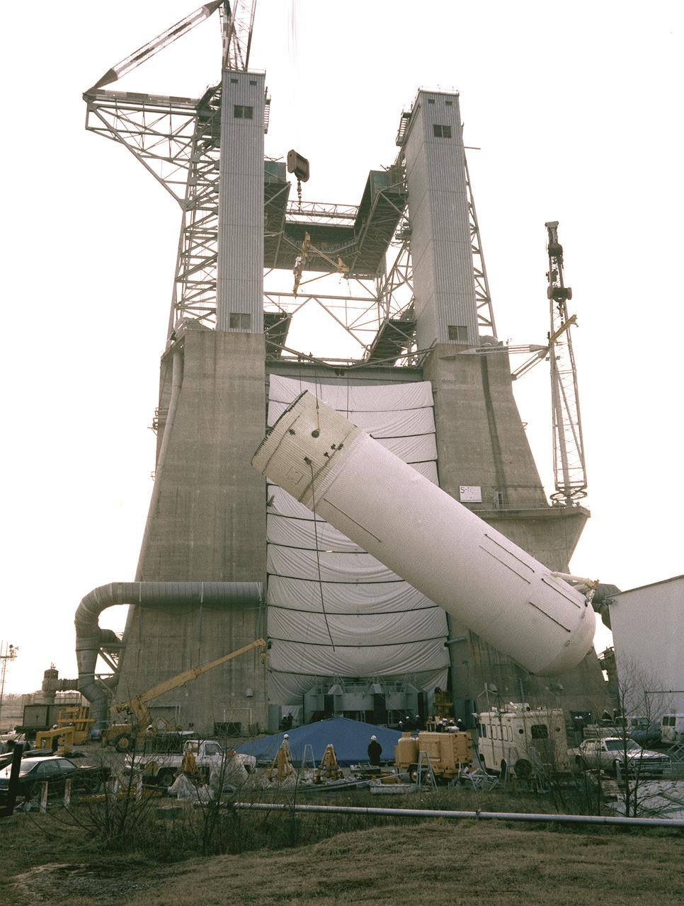 A liquid hydrogen tank of the Shuttle's external tank (ET) is installed into the S-1C Test Stand for a structural test at the Marshall Space Flight Center. At 154-feet long and more than 27-feet in diameter, the ET is the largest component of the Space Shuttle, the structural backbone of the entire Shuttle system, and is the only part of the vehicle that is not reusable. The ET is manufactured at the Michoud Assembly Facility near New Orleans, Louisiana, by the Martin Marietta Corporation under management of the Marshall Space Flight Center.