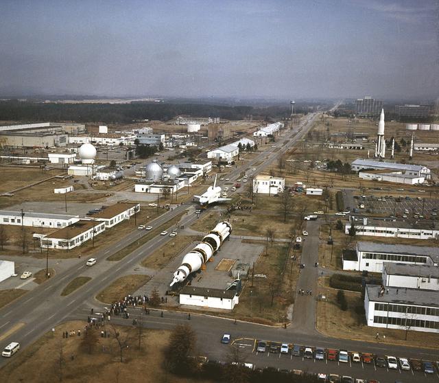 In this view looking northwest over the Marshall Space Flight Center (MSFC), the Shuttle Orbiter Enterprise is seen heading South on Rideout Road near the Redstone Arsenal Fire Station as it is being transported to MSFC's building 4755 for later Mated Vertical Ground Vibration tests (MVGVT) at MSFC's Dynamic Test Stand. The tests marked the first time ever that the entire shuttle complement (including Orbiter, external tank, and solid rocket boosters) were mated vertically.