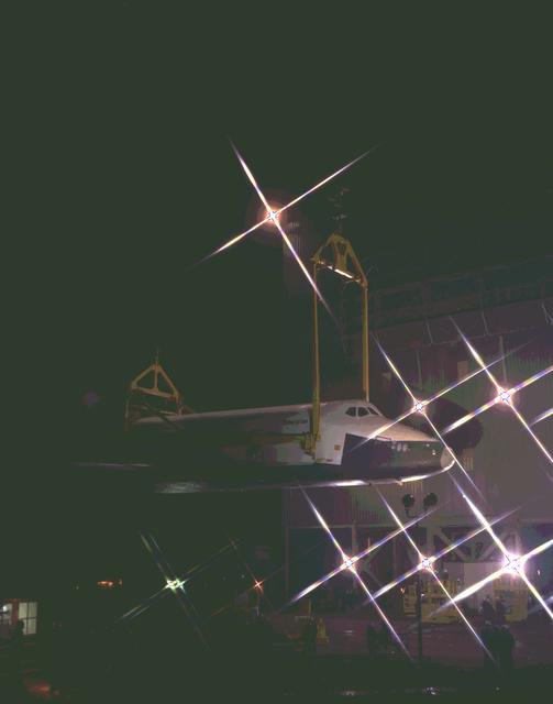 Shown here is the Shuttle Orbiter Enterprise being erected, just prior to installation into the Marshall Space Flight Center (MSFC) Dynamic Test Stand, for a Mated Vertical Ground Vibration Test (MVGVT).