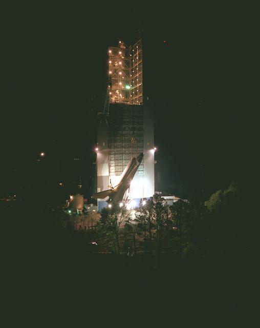 In preparation for the Mated Vertical Ground Vibration Test (MVGVT), the Shuttle Orbiter Enterprise is being erected just prior to installation into the Marshall Space Flight Center's Dynamic Test Stand for testing. This particular view is from Test Stand 500.