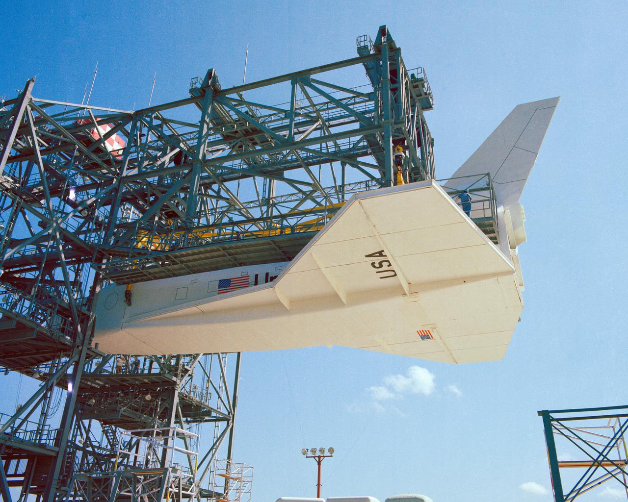 CAPE CANAVERAL, Fla. – At NASA's Kennedy Space Center in Florida, the space shuttle mock-up, dubbed Pathfinder, is attached to the Mate-Demate Device for at fit-check Oct. 19, 1978. The mock-up, constructed at NASA's Marshall Space Flight Center in Huntsville, Ala., possessed the general dimensions, weight and balance of a real space shuttle. It was shipped to Kennedy by barge and then used to fit-check the work platforms of the Mate-Demate Device, orbiter processing facilities and Vehicle Assembly Building, as well as support ground crew training. It also was used to rehearse post-landing procedures at Kennedy's Shuttle Landing Facility.  After being on display at the 'Great Space Shuttle Exposition' in Tokyo from June 1983 to August 1984, the mock-up returned to Marshall and now is on permanent display at the U.S. Space and Rocket Center near Huntsville. Photo credit: NASA