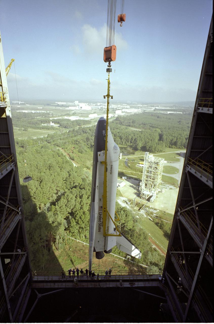The Shuttle Orbiter Enterprise is being installed into liftoff configuration at Marshall Space Flight Center's Dynamic Test Stand for Mated Vertical Ground Vibration tests (MVGVT). The tests marked the first time ever that the entire shuttle complement (including Orbiter, external tank, and solid rocket boosters) were mated vertically.
