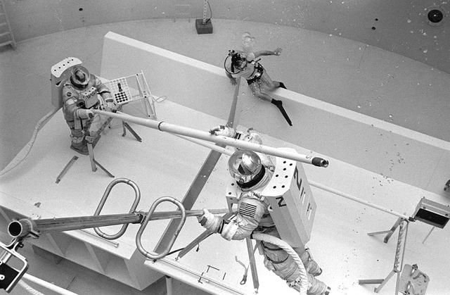 Once the United States' space program had progressed from Earth's orbit into outerspace, the prospect of building and maintaining a permanent presence in space was realized. To accomplish this feat, NASA launched a temporary workstation, Skylab, to discover the effects of low gravity and weightlessness on the human body, and also to develop tools and equipment that would be needed in the future to build and maintain a more permanent space station. The structures, techniques, and work schedules had to be carefully designed to fit this unique construction site. The components had to be lightweight for transport into orbit, yet durable. The station also had to be made with removable parts for easy servicing and repairs by astronauts. All of the tools necessary for service and repairs had to be designed for easy manipulation by a suited astronaut. And construction methods had to be efficient due to limited time the astronauts could remain outside their controlled environment. In lieu of all the specific needs for this project, an environment on Earth had to be developed that could simulate a low gravity atmosphere. A Neutral Buoyancy Simulator (NBS) was constructed by NASA Marshall Space Flight Center (MSFC) in 1968. Since then, NASA scientists have used this facility to understand how humans work best in low gravity and also provide information about the different kinds of structures that can be built. With the help of the NBS, building a space station became more of a reality. In a joint venture between NASA/Langley Research Center in Hampton, VA and MSFC, the Assembly Concept for Construction of Erectable Space Structures (ACCESS) was developed and demonstrated at MSFC's NBS. The primary objective of this experiment was to test the ACCESS structural assembly concept for suitability as the framework for larger space structures and to identify ways to improve the productivity of space construction. Pictured is a demonstration of ACCESS.