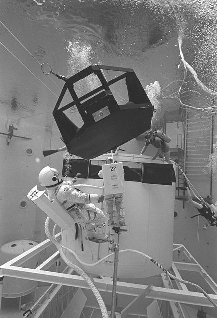 The Hubble Space Telescope (HST) is a cooperative program of the European Space Agency (ESA) and the National Aeronautical and Space Administration (NASA) to operate a long-lived space-based observatory; it was the first and flagship mission of NASA's Great Observatories program. The HST program began as an astronomical dream in the 1940s. During the 1970s and 1980s, HST was finally designed and built; and became operational in the 1990s. HST was deployed into a low-Earth orbit on April 25, 1990 from the cargo bay of the Space Shuttle Discovery (STS-31). The design of the HST took into consideration its length of service and the necessity of repairs and equipment replacement by making the body modular. In doing so, subsequent shuttle missions could recover the HST, replace faulty or obsolete parts and be re-released. Pictured is MSFC's Neutral Buoyancy Simulator which served as the test center for shuttle astronauts training for Hubble related missions. Shown is an astronaut training on a mock-up of a modular section of the HST in removal/replacement of scientific instruments.