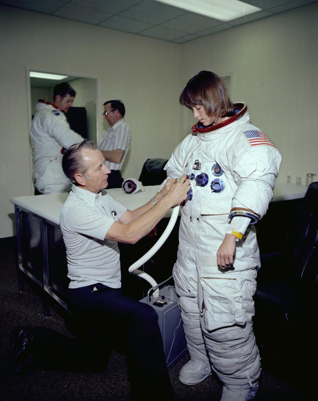 The Hubble Space Telescope (HST) is a cooperative program of the European Space Agency (ESA) and the National Aeronautical and Space Administration (NASA) to operate a long-lived space-based observatory. It was the flagship mission of NASA's Great Observatories program. The HST program began as an astronomical dream in the 1940s. During the 1970s and 1980s, the HST was finally designed and built becoming operational in the 1990s. The HST was deployed into a low-Earth orbit on April 25, 1990 from the cargo bay of the Space Shuttle Discovery (STS-31). The design of the HST took into consideration its length of service and the necessity of repairs and equipment replacement by making the body modular. In doing so, subsequent shuttle missions could recover the HST, replace faulty or obsolete parts and be re-released. Marshall Space Flight Center’s (MSFC's) Neutral Buoyancy Simulator (NBS) served as the test center for shuttle astronauts training for Hubble related missions. Shown is astronaut Anna Fisher suiting up for training on a mockup of a modular section of the HST for an axial scientific instrument change out.