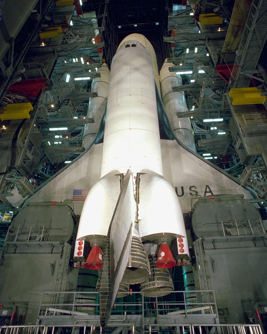KENNEDY SPACE CENTER, FLA. - Assembly of the first Space Shuttle vehicle, scheduled to make its first orbital test flight in March 1981, was completed today with the mating of the Orbiter Columbia to its external tank in the Vehicle Assembly Building's High Bay 3. Columbia, shown here still attached to its hoisting sling, was moved to the VAB on Nov. 24 having completed tests and tile installation in the adjacent Orbiter Processing Facility. The other Shuttle components, the twin solid rocket boosters and the external propellant tank, were stacked on the Mobile Launcher Platform in High Bay 3 in January and November of this year, respectively. The current schedule calls for the rollout of the assembled Space Shuttle to Pad A at Launch Complex 39 shortly after Christmas.
