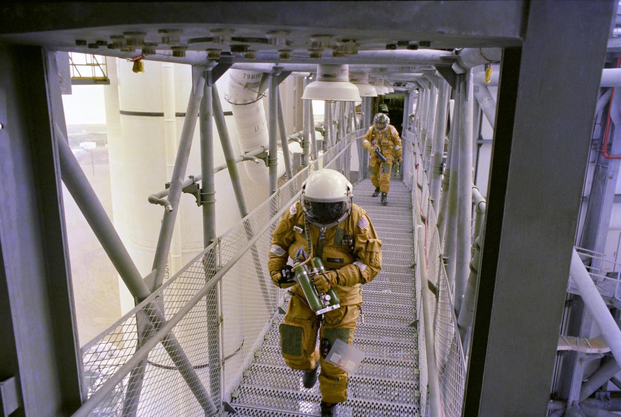 KENNEDY SPACE CENTER, FLA.  - On the Fixed Service Structure on Launch Complex 39A, space shuttle prime and backup astronaut crews plus other astronauts and ground personnel are given training on the use of the emergency pad escape system known as the “slidewire”.  The slidewire system provides a quick escape from upper launch pad platforms in case of a serious emergency.  The flight crews wear the spacesuits and other equipment to be worn during a mission, but sandbags are used to duplicate the weight of riders in the slidewire baskets during the training.  The STS-1 mission, known as a shuttle systems test flight, will seek to demonstrate safe launch into orbit and safe return of the orbiter and crew and verify the combined performance of the entire shuttle vehicle -- orbiter, solid rocket boosters and external tank.  STS-1 will be launched from Pad A at the Kennedy Space Center's Launch Complex 39 no earlier than March 1981.