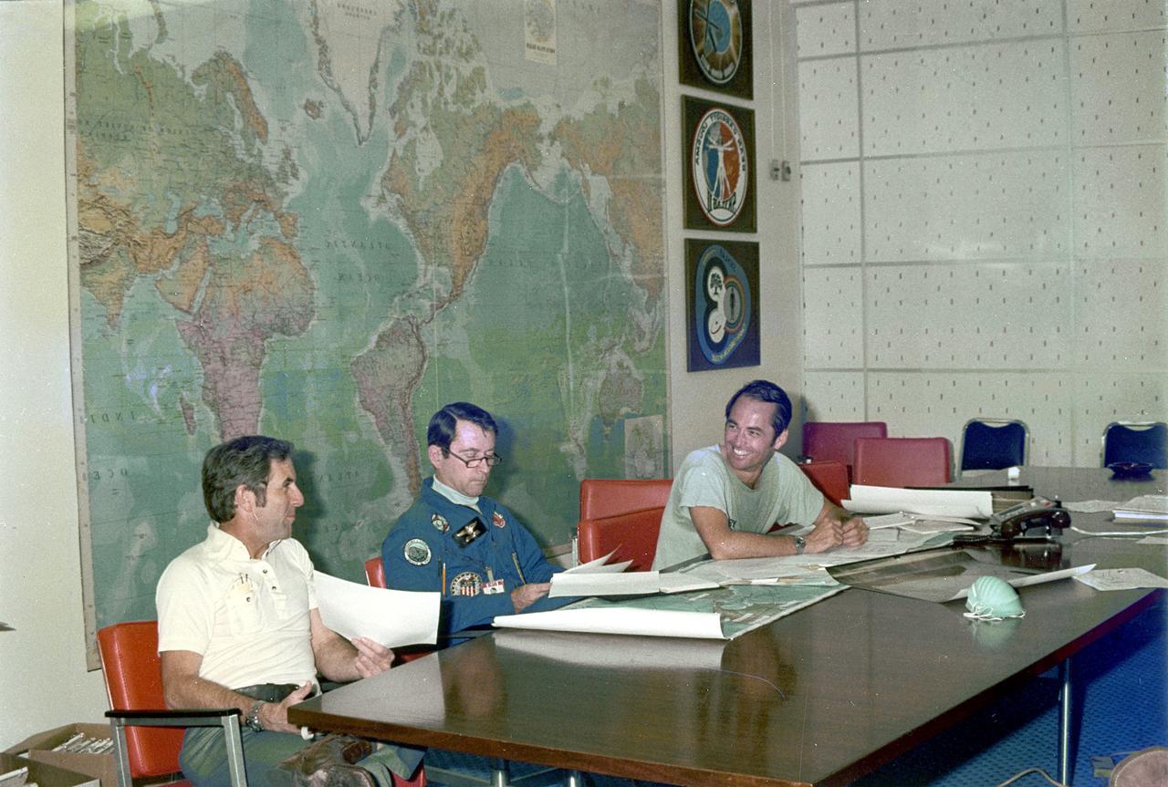 KENNEDY SPACE CENTER, FLA. -  Space Shuttle prime crew members Robert Crippen, left, pilot, and John Young, center, commander, along with backup crewman Richard Truly, study forecasts of weather conditions for launch of the maiden flight of STS-1, America’s first reusable space transportation system.