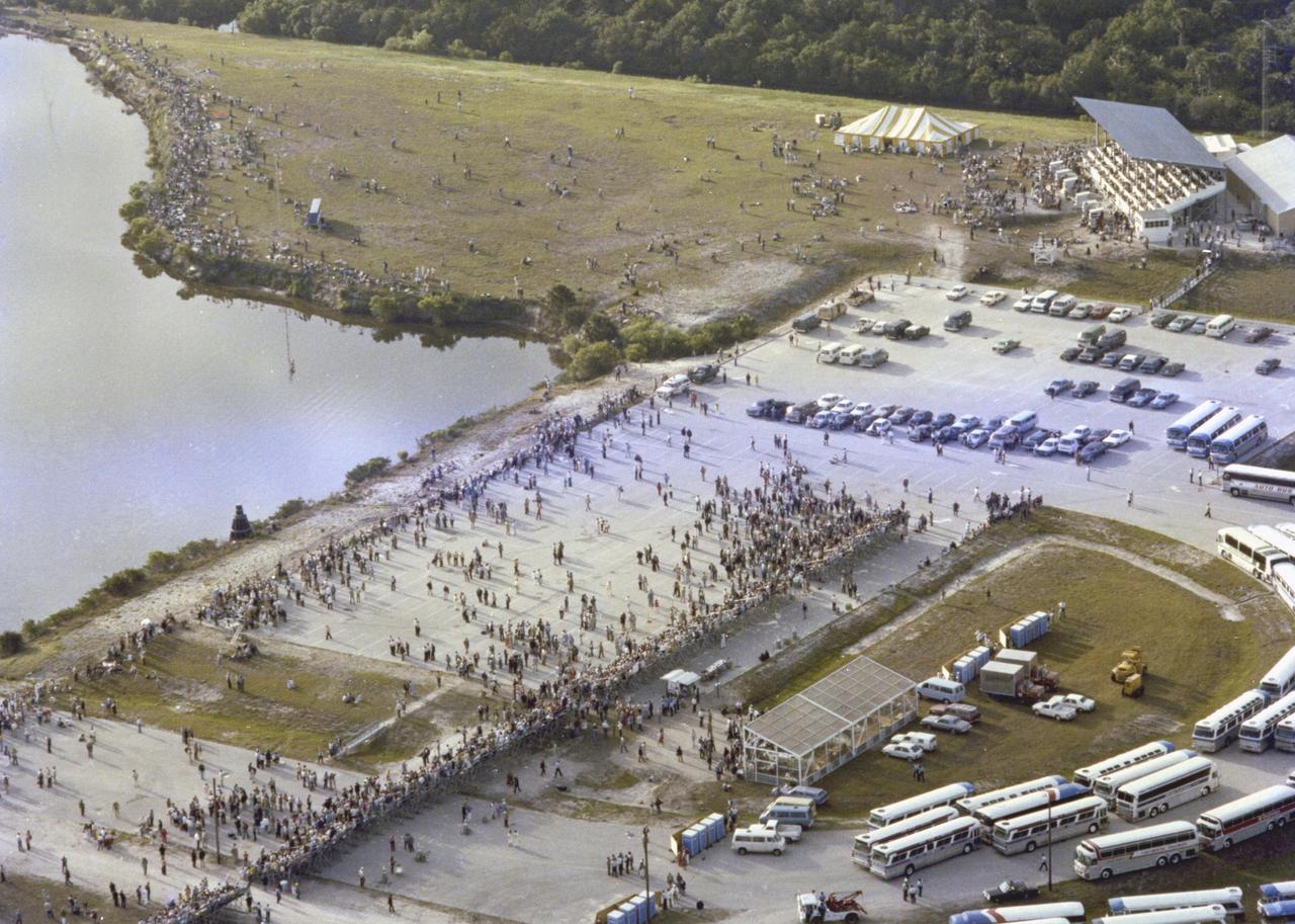 KENNEDY SPACE CENTER, FLA.  -  Viewed from the top of the Vehicle Assembly Building, crowds wait in vain for the launch of the maiden flight of the Space Shuttle, “scrubbed” on April 10.  Visible at center is the “V.I.P.” site, with waiting buses parked at lower right.  Above are the NASA Complex 39 Press Site and viewing stands, and major news media facilities.  The STS-1 mission, known as a shuttle systems test flight, will seek to demonstrate safe launch into orbit and safe return of the orbiter and crew and verify the combined performance of the entire shuttle vehicle -- orbiter, solid rocket boosters and external tank.