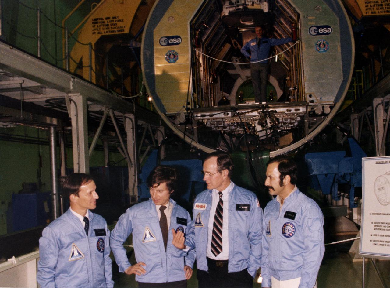 KENNEDY SPACE CENTER, FLA. -- Vice President George H.W. Bush, third from left, is pictured with the Spacelab engineering module at the Spacelab Arrival Ceremony in the Operations and Checkout Building as he visits with, from left, astronaut Claude Nicollier, European Space Agency, and payload specialists Ulf Marbod, West Germany, and Wubbo Ockels, the Netherlands. Overhead, in the module, is Owen K. Garriott, U.S. astronaut. The European-built Spacelab, designed to provide a shirt-sleeve environment for scientists working in Earth orbit, is scheduled to fly its first mission in the payload bay of the Space Shuttle in 1983.