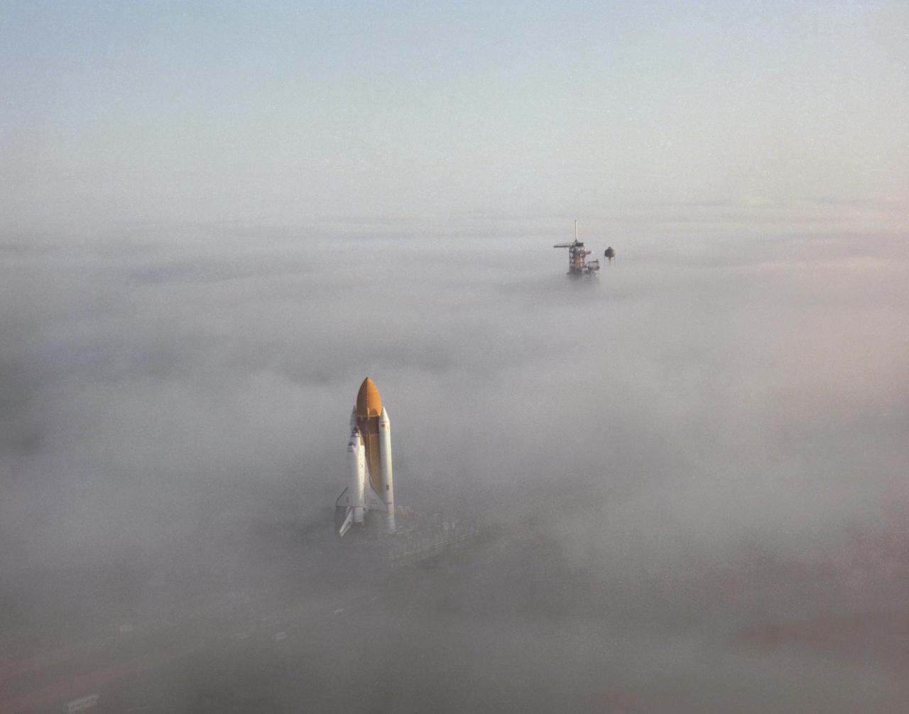 KENNEDY SPACE CENTER, FLA. -  The Space Shuttle Challenger presents a surrealistic impression as it moves through the fog on its way down the 3 ½-mile crawlerway enroute to Launch Pad 39A.  The fully assembled Shuttle, weighing 12,000 pounds less than its predecessor Columbia, completed the trip from the Vehicle Assembly Building in shortly over 6 hours.  The sixth Shuttle flight, which will be the first for the Challenger, is scheduled for no earlier than January 24, 1983.
