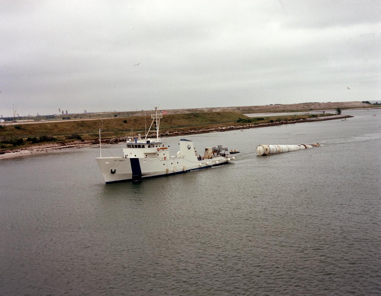 The towing ship, Liberty, towed a recovered solid rocket booster (SRB) for the STS-5 mission to Port Canaveral, Florida. The recovered SRB would be inspected and refurbished for reuse. The Shuttle's SRB's and solid rocket motors (SRM's) are the largest ever built and the first designed for refurbishment and reuse. Standing nearly 150-feet high, the twin boosters provide the majority of thrust for the first two minutes of flight, about 5.8 million pounds. The requirement for reusability dictated durable materials and construction to preclude corrosion of the hardware exposed to the harsh seawater environment. The SRB contains a complete recovery subsystem that includes parachutes, beacons, lights, and tow fixture.