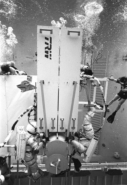 The Space Platform was first conceived as a launching site for deep space exploration. The original idea was to build this space platform either on the moon's surface or near lunar orbit. It would be used as a staging base, where the reusable launch vehicles (later known as Space Shuttles) would ferry machinery and equipment to assemble deep space exploration vehicles. Replaced by the Space Station concept, the space platform idea was never completed. However, early in the space platform development, astronauts trained at the Marshall Space Flight Center's (MSFC) Neutral Buoyancy Simulator (NBS), as pictured here, working on solar array equipment. This experiment was deployed from the shuttle to study the motions of large structures in space. Similar arrays will be used on the Space Station and large observatory spacecraft in the future.