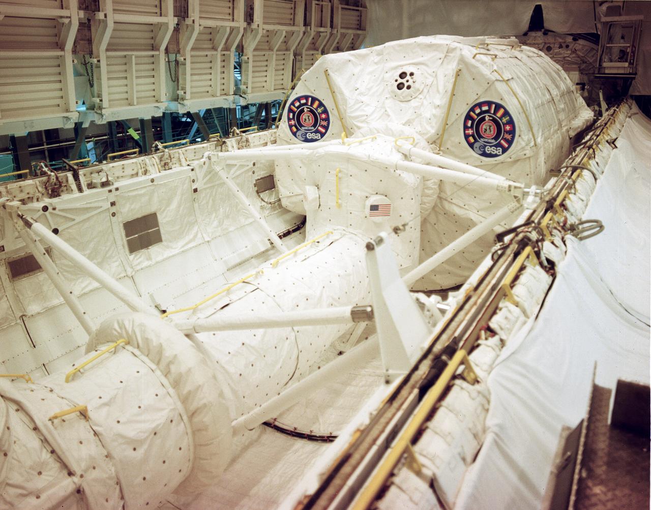 This photograph shows the Spacelab-1 module and Spacelab access turnel being installed in the cargo bay of orbiter Columbia for the STS-9 mission. The oribiting laboratory, built by the European Space Agency, is capable of supporting many types of scientific research that can best be performed in space. The Spacelab access tunnel, the only major piece of Spacelab hardware made in the U.S., connects the module with the mid-deck level of the orbiter cabin. The first Spacelab mission, Spacelab-1, sponsored jointly and shared equally by NASA and the European Space Agency, was a multidisciplinary mission; that is, investigations were performed in several different fields of scientific research. The overall goal of the mission was to verify Spacelab performance through a variety of scientific experiments. The disciplines represented by these experiments were: astronomy and solar physics, earth observations, space plasma physics, materials sciences, atmospheric physics, and life sciences. International in nature, Spacelab-1 conducted experiments from the United States, Japan, the Netherlands, United Kingdom, Beluga, France, Germany, Italy, and Switzerland. Spacelab-1, was launched from the Kennedy Space Center on November 28, 1983 aboard the orbiter Columbia (STS-9). The Marshall Space Flight Center was responsible for managing the Spacelab missions.