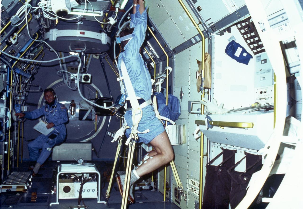 In this Spacelab-1 mission onboard photograph, astronaut Byron Lichtenberg performs a drop experiment, one of the Vestibular Experiments in Space investigations. The experiment examined spinal reflexes to determine whether they changed in microgravity. In Earth's environment, the otoliths signal the muscles to prepare for jolts associated with falling. During the flight, the normal reflex between the otoliths and the muscles was partially inhibited early in flight, declined further as the flight progressed, and returned to normal immediately after landing, suggesting that the brain ignored or reinterpreted otolith signals during space flight. Crewmembers reported a lack of awareness of position and location of feet, difficulty in maintaining balance, and a perception that falls were more sudden, faster, and harder than similar drops experienced in preflight. Crewmembers experienced illusions as they performed prescribed movement tests. When crew members viewed various targets and then pointed at them while blindfolded, their perception of target location and position of their own limbs was inaccurate in flight compared with similar tests on the ground. The Spacelab-1 was a multidisciplinary mission; that is, investigations were performed in several different fields of scientific research. The overall goal of the mission was to verify Spacelab performance through a variety of scientific experiments. The Spacelab-1 was launched aboard the Space Shuttle Orbiter Columbia for the STS-9 mission on November 28, 1983. The Marshall Space Flight Center had management responsibilities for the mission.