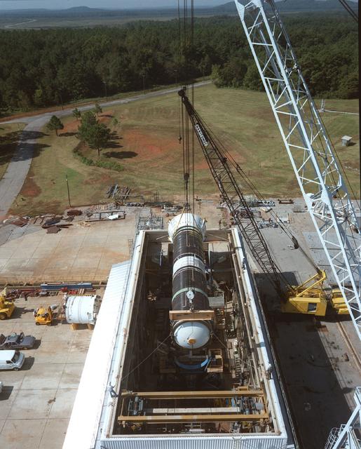 Marshall Space Flight Center workers install Structural Test Article Number Three (STA-3) into a Center test facility. From December 1987 to April 1988, STA-3 (a test model of the Redesigned Solid Rocket Motor) underwent a series of six tests at the Marshall Center designed to demonstrate the structural strength of the Space Shuttle's Solid Rocket Booster, redesigned after the January 1986 Challenger accident. 