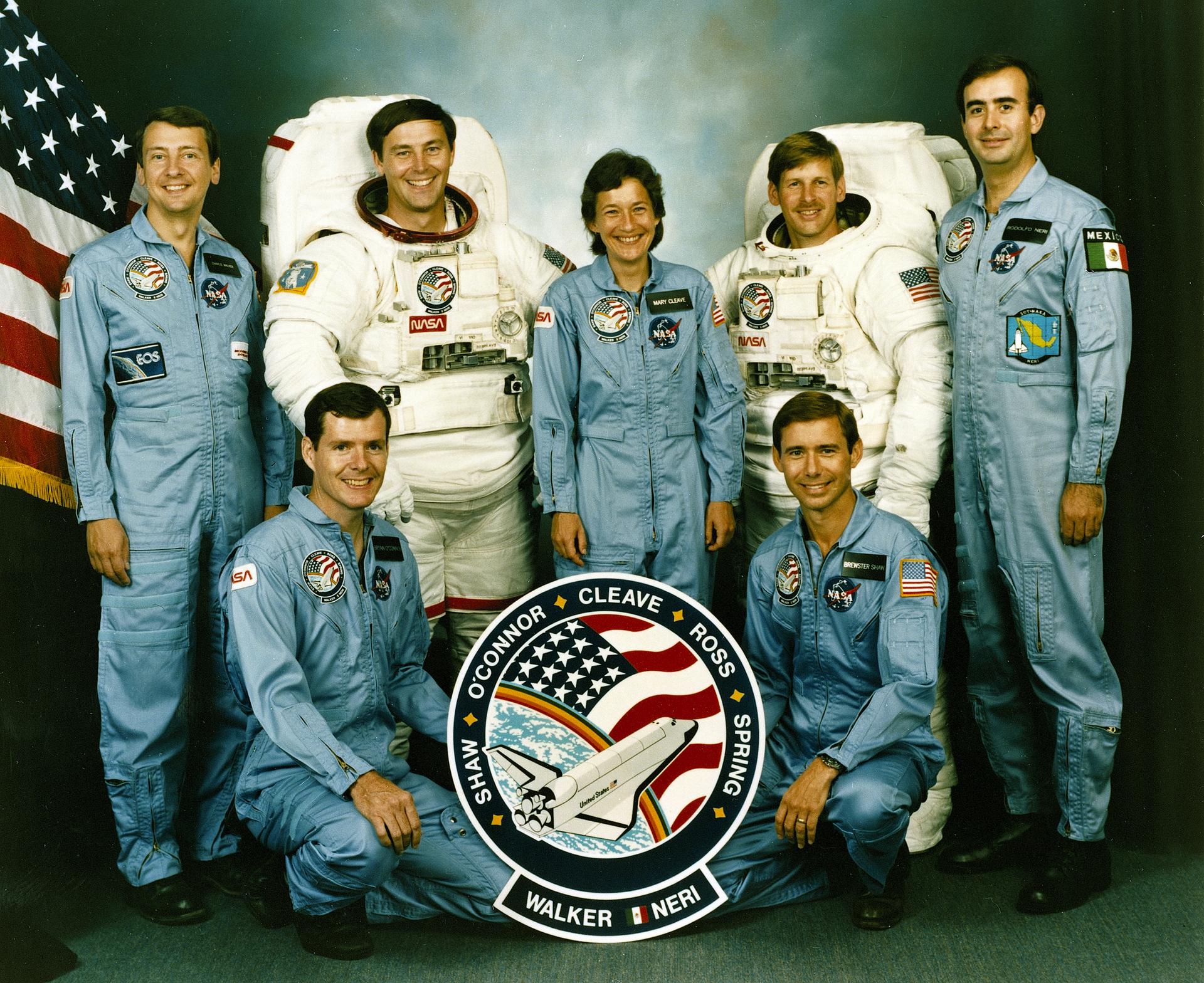 The STS-61B crew photo with the crew patch in front of the seven astronauts