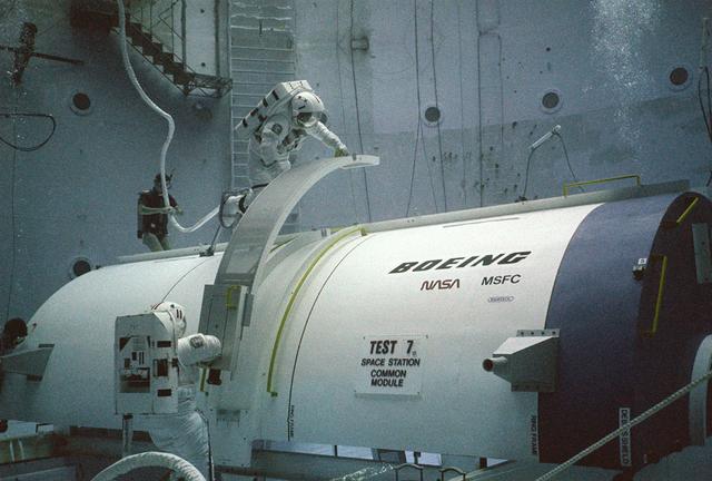 Skylab's success proved that scientific experimentation in a low gravity environment was essential to scientific progress. A more permanent structure was needed to provide this space laboratory. President Ronald Reagan, on January 25, 1984, during his State of the Union address, claimed that the United States should exploit the new frontier of space, and directed NASA to build a permanent marned space station within a decade. The idea was that the space station would not only be used as a laboratory for the advancement of science and medicine, but would also provide a staging area for building a lunar base and manned expeditions to Mars and elsewhere in the solar system. President Reagan invited the international community to join with the United States in this endeavour. NASA and several countries moved forward with this concept. By December 1985, the first phase of the space station was well underway with the design concept for the crew compartments and laboratories. Pictured are two NASA astronauts, at Marshall Space Flight Center's (MSFC) Neutral Buoyancy Simulator (NBS), practicing construction techniques they later used to construct the space station after it was deployed.