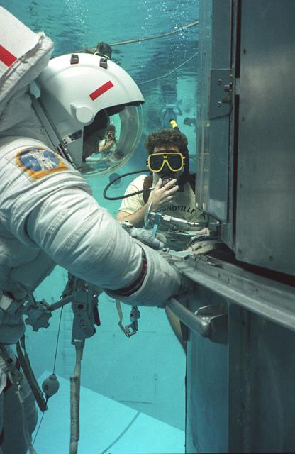 Prior to its launch in April 1990, the Hubble Space Telescope (HST) went through years of development and testing. The HST was the first of its kind and the scientific community could only imagine the fruits of their collective labors. However, prior to its launch, more practical procedures, such as astronaut training, had to be developed. As the HST was to remain in orbit for years, it became apparent that on-orbit maintenance routines would have to be developed. The best facility to develop these maintenance practices was at the Neutral Buoyancy Simulator (NBS) at the Marshall Space Flight Center (MSFC). The NBS provided mock-ups of the HST (in sections), a Remote Manipulator System (RMS), and a shuttle's cargo bay pallet. This real life scenario provided scientists, engineers, and astronauts a practical environment to work out any problems with a plarned on-orbit maintenance mission. Pictured is an astronaut in training with a mock-up section of the HST, practicing using tools especially designed for the task being performed.