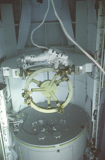 Preparing for the eventual launch of the Hubble Space Telescope (HST), an astronaut prepares himself for the rigorous duties of maintenance and repairs after launch, at Marshall Space Flight Center's (MSFC) Neutral Buoyancy Simulator (NBS). The NBS provided mock-ups of the HST, the Remote Manipulator System (RMS), the orbiter's cargo bay, and the low-gravity environment that the astronauts would encounter while working in space. All aspects of shuttle missions were pre-plarned and practiced at the NBS to forego any problems in space.