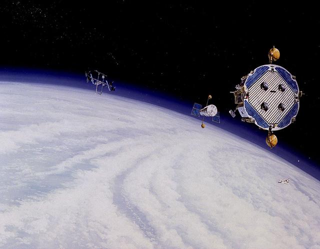 In this 1986 artist's concept, the Orbital Maneuvering Vehicle (OMV), at right, prepares to reboost the Hubble Space Telescope after being deployed from an early Space Station configuration (left). As envisioned by Marshall Space Flight Center plarners, the OMV would be a remotely-controlled free-flying space tug which would place, rendezvous, dock, and retrieve orbital payloads.