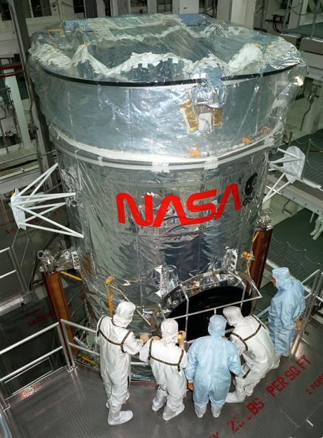 The Hubble Space Telescope (HST) pictured in the Vertical Processing Facility (VPF) support fixture during final testing and verification at the Lockheed assembly plant.