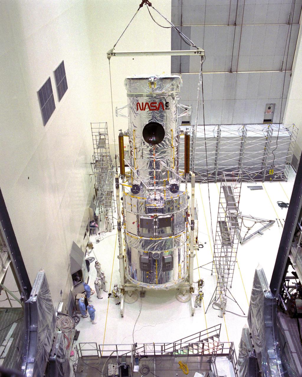 CAPE CANAVERAL, Fla. -- At the Kennedy Space Center in Florida, the Hubble Space Telescope is lifted into the vertical position in the Vertical Processing Facility as work begins to process the 94-inch primary mirror telescope for launch on the Discovery on STS-31 in March 1990. With Hubble, astronomers will be able to view 97 percent of the known universe, and will be able to get pictures unlimited and undistorted by the Earth’s atmosphere. Compared with Earth-based observatories, Hubble will be able to view celestial objects that are 50 times fainter, provide images that are 10 times sharper, and see objects that are seven times further away. Photo Credit: NASA