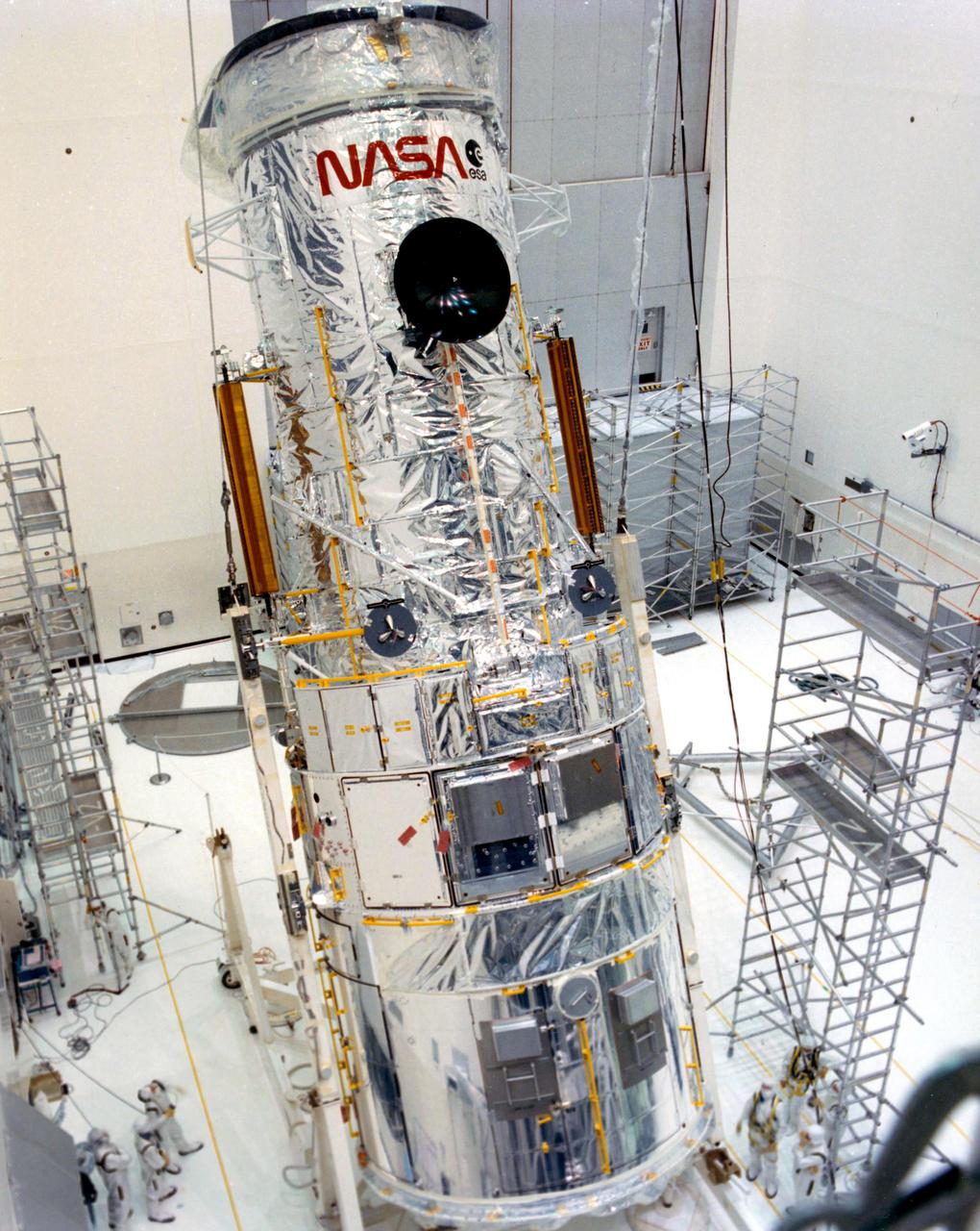 KENNEDY SPACE CENTER, FLA. -- The Hubble Space Telescope (HST) is lifted into the vertical position in the Vertical Processing Facility as work begins at KSC to process the 94-inch primary mirror telescope for launch on Discovery on Space Shuttle Mission STS-31 in March 1990. With HST, astronomers will be able to view 97 percent of the known universe, and will be able to get pictures unlimited and undistorted by the Earth's atmosphere. Compared with earth-based observatories, the HST will be able to view celestial objects that are 50 times fainter, provide images that are 10 times sharper, and see objects that are seven times farther away. .