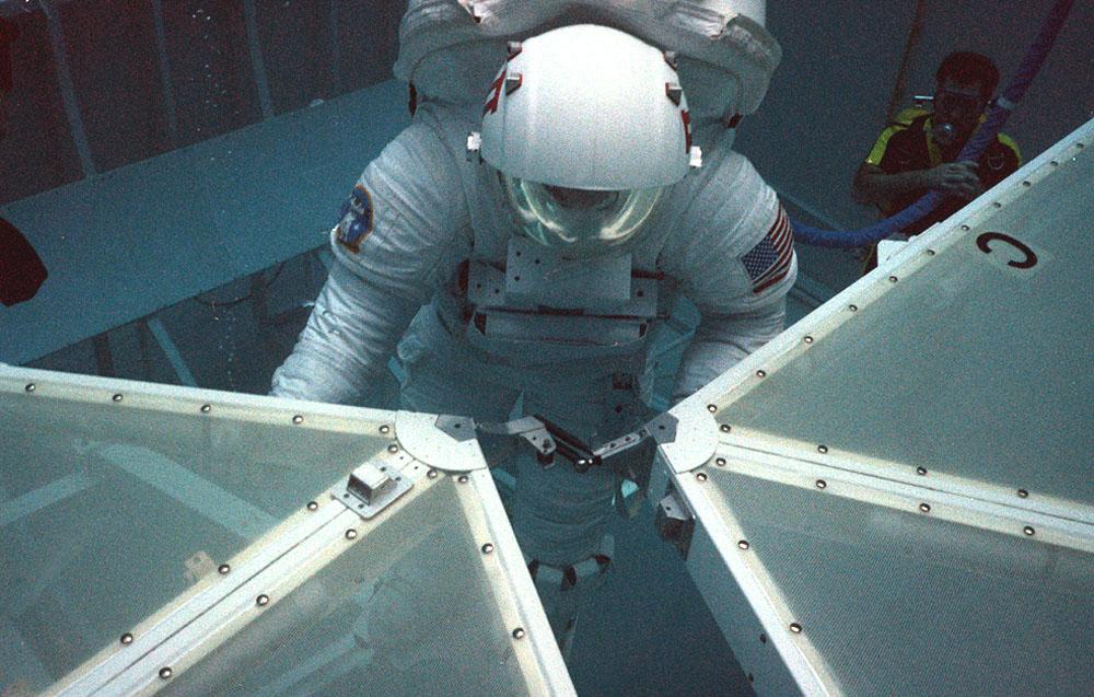 Marshall scientist practices assembling the solar panel array for the space station during the Collector Panel Assembly Test (COPAT) at Marshall's Neutral Buoyancy Simulator (NBS).