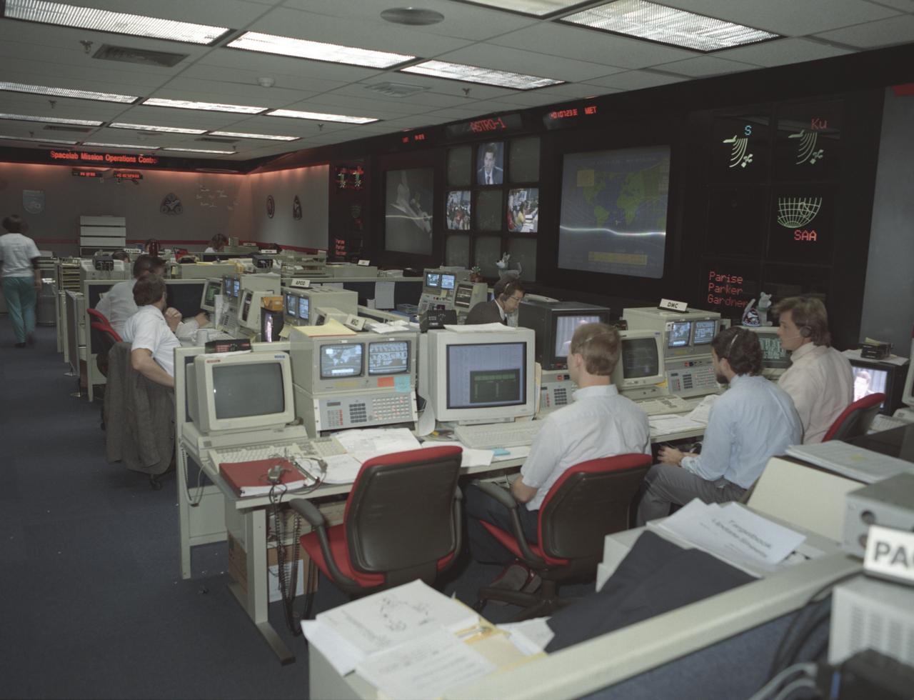 This photograph was taken during the Astro-1 mission (STS-35) showing activities at NASA's new Payload Operations Control Center (POCC) at the Marshall Space Flight Center. The POCC was the air/ground communication charnel used between the astronauts and ground control teams during the Spacelab missions. Teams of controllers and researchers directed on-orbit science operations, sent commands to the spacecraft, received data from experiments aboard the Space Shuttle, adjusted mission schedules to take advantage of unexpected science opportunities or unexpected results, and worked with crewmembers to resolve problems with their experiments.
