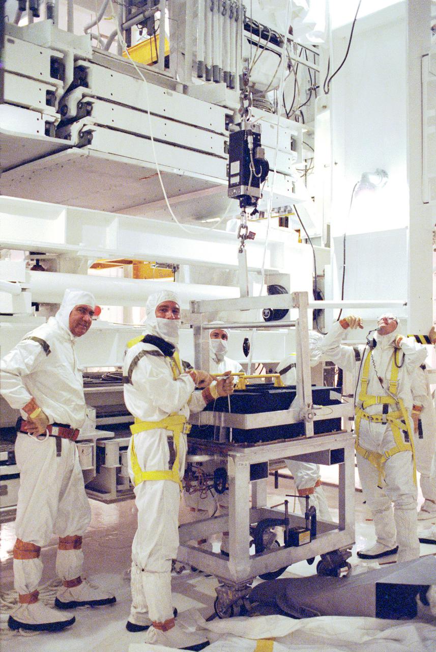 KENNEDY SPACE CENTER, FLA. -- Technicians in the Payload Changeout Room at Pad 39-B are removing the batteries from the Hubble Space Telescope for recharging. The two sets of six batteries apiece will be taken to the battery lab inside the Vehicle Assembly Building for 130 hours of recharging, and then reinstalled in the telescope. Recharging became necessary when the first launch attempt of Space Shuttle Mission STS-31 was scrubbed April 10. A second try is set for April 24 at 8:30 a.m. EDT.