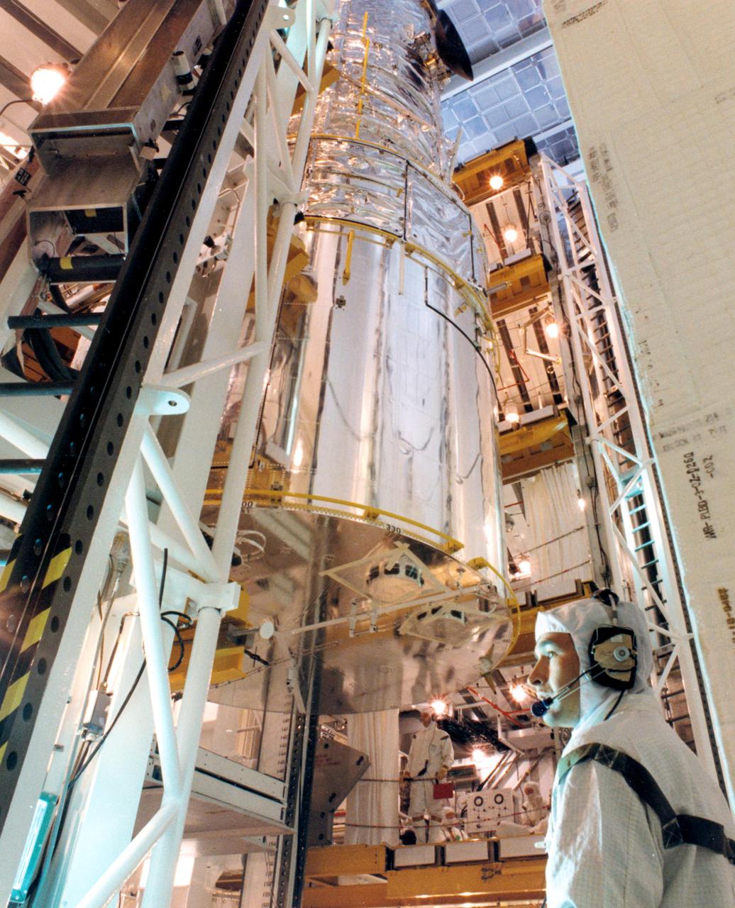 KENNEDY SPACE CENTER, FLA. -- The bus-size Hubble Space Telescope (HST) is carefully being transferred on March 29 from the surgically clean Payload Changeout Room at Launch Pad 39B into the cargo bay of the orbiter Discovery.  The payload ground handling mechanism (left) is a device that extends the HST into the cargo bay (right), allowing workers to fasten it in place with four retention latches.  Deployment of Hubble will occur during the five-day flight of Space Shuttle Mission STS-31, set for April 10.  With HST, astronomers will be able to view 97 percent of the known universe, and will be able to get pictures unlimited and undistorted by the Earth's atmosphere. Compared with earth-based observatories, the HST will be able to view celestial objects that are 50 times fainter, provide images that are 10 times sharper, and see objects that are seven times farther away. .