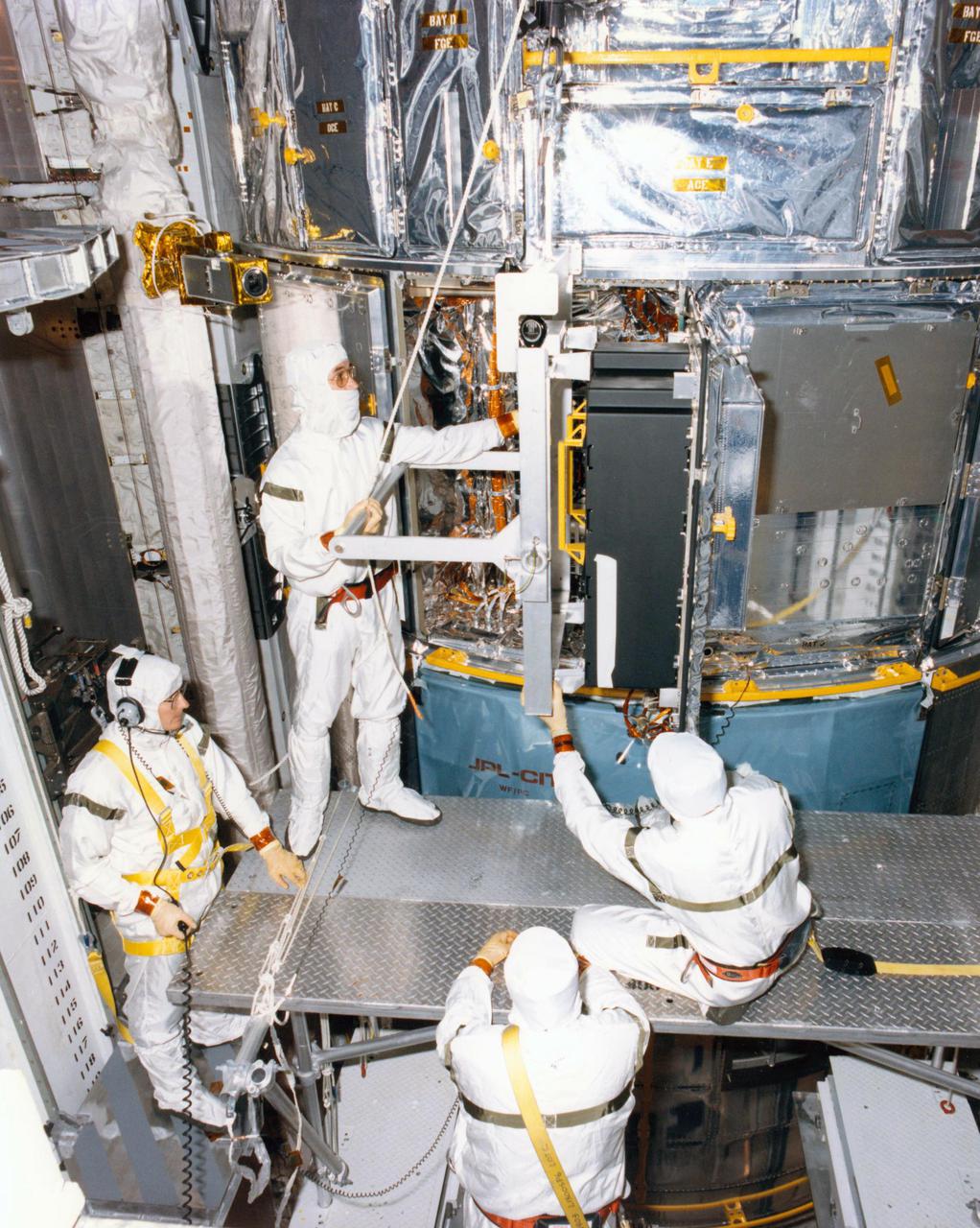 KENNEDY SPACE CENTER, FLA. -- Technicians in the Payload Changeout Room at Launch Pad 39B are removing the batteries from the Hubble Space Telescope for recharging. The two sets of six batteries apiece will be taken to the battery lab inside the Vehicle Assembly Building for 130 hours of recharging, and then reinstalled in the telescope. The recharging became necessary when the first launch attempt of Space Shuttle Mission STS-31 was scrubbed April 10. A second try is set for April 24 at 8:31 a.m. EDT.