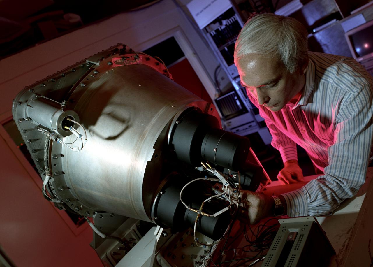 In this photograph, Dr. Gerald Fishman of the Marshall Space Flight Center (MSFC), a principal investigator of the Compton Gamma-Ray Observatory's (GRO's) instrument, the Burst and Transient Source Experiment (BATSE), works on the BATSE detector module. For nearly 9 years, GRO's BATSE, designed and built by MSFC, kept an unblinking watch on the universe to alert scientist to the invisible, mysterious gamma-ray bursts. By studying gamma-rays from objects like black holes, pulsars, quasars, neutron stars, and other exotic objects, scientists could discover clues to the birth, evolution, and death of star, galaxies, and the universe. The gamma-ray instrument was one of four major science instruments aboard the Compton. It consisted of eight detectors, or modules, located at each corner of the rectangular satellite to simultaneously scan the entire universe for bursts of gamma-rays ranging in duration from fractions of a second to minutes. Because gamma-rays are so powerful, they pass through conventional telescope mirrors. Instead of a mirror, the heart of each BATSE module was a large, flat, transparent crystal that generated a tiny flash of light when struck by a gamma-ray. With an impressive list of discoveries and diverse accomplishments, BATSE could claim to have rewritten astronomy textbooks. Launched aboard the Space Shuttle Orbiter Atlantis during the STS-35 mission in April 1991, the GRO reentered the Earth's atmosphere and ended its successful 9-year mission in June 2000.