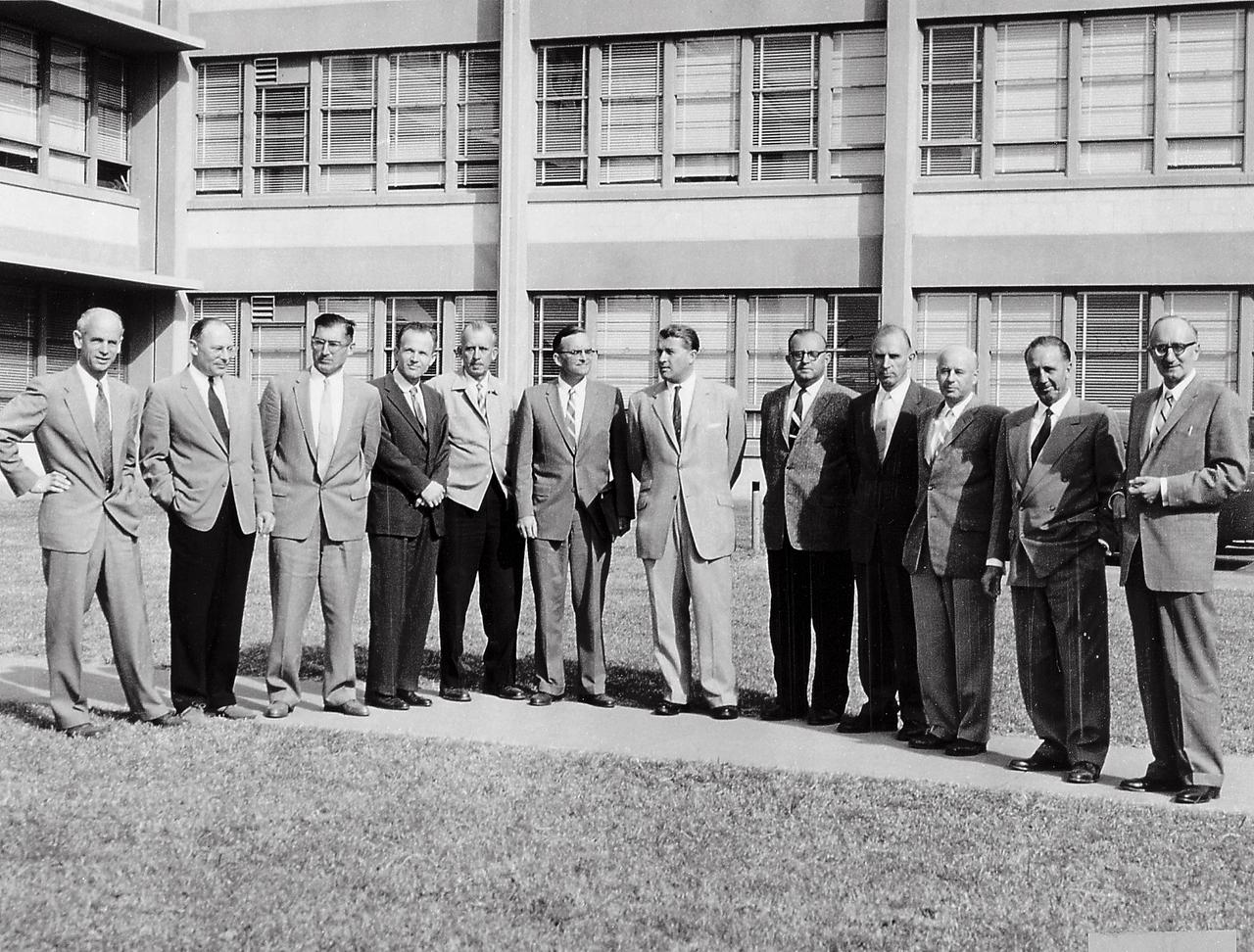 Twelve scientific specialists of the Peenemuende team at the front of Building 4488, Redstone Arsenal, Huntsville, Alabama. They led the Army's space efforts at ABMA before transfer of the team to National Aeronautic and Space Administration (NASA), George C. Marshall Space Flight Center (MSFC). (Left to right) Dr. Ernst Stuhlinger, Director, Research Projects Office; Dr. Helmut Hoelzer, Director, Computation Laboratory: Karl L. Heimburg, Director, Test Laboratory; Dr. Ernst Geissler, Director, Aeroballistics Laboratory; Erich W. Neubert, Director, Systems Analysis Reliability Laboratory; Dr. Walter Haeussermarn, Director, Guidance and Control Laboratory; Dr. Wernher von Braun, Director Development Operations Division; William A. Mrazek, Director, Structures and Mechanics Laboratory; Hans Hueter, Director, System Support Equipment Laboratory;Eberhard Rees, Deputy Director, Development Operations Division; Dr. Kurt Debus, Director Missile Firing Laboratory; Hans H. Maus, Director, Fabrication and Assembly Engineering Laboratory