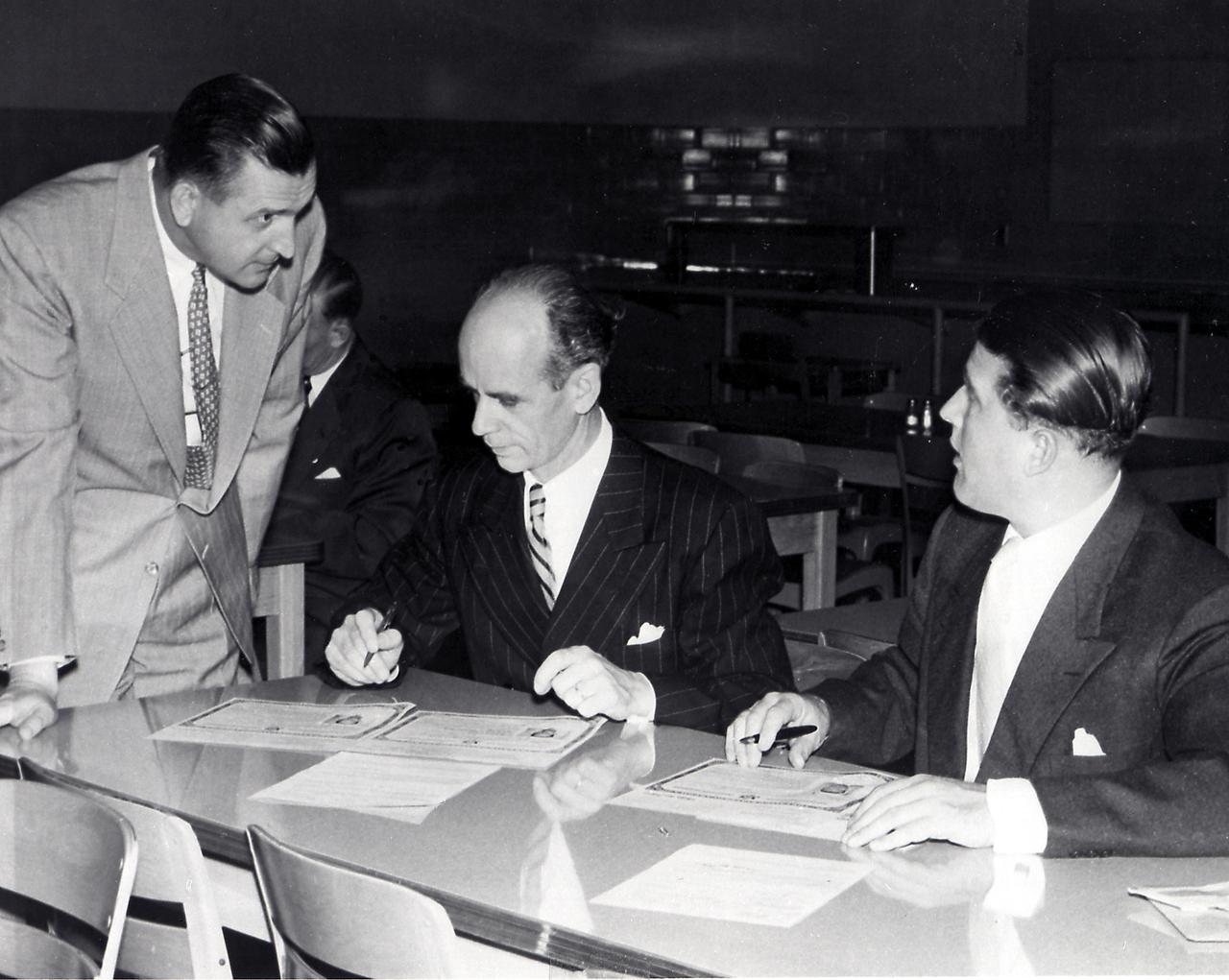 The members of the Peenemuende team and their family members were awarded the United States citizenship on April 14, 1955. Pictured here is Dr. Ernst Stuhlinger (middle) and Dr. Wernher von Braun signing U.S. citizenship certificates. Martin Schilling is at left. 
