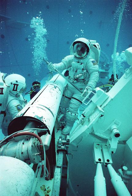 Two years prior to being used during a shuttle mission, the Transfer to Orbit System (TOS) is being demonstrated at Marshall Space Flight Center's (MSFC) Neutral Buoyancy Simulator (NBS). TOS is an upper stage launch system used to place satellites into higher orbits. TOS was used only once, on September 12, 1993 when the Space Shuttle Discovery (STS51) deployed ACTS (Advanced Communications Technology Satellite). The test pictured was to provide an evaluation of the extravehicular activity (EVA) tools that were to be used by future shuttle crews.