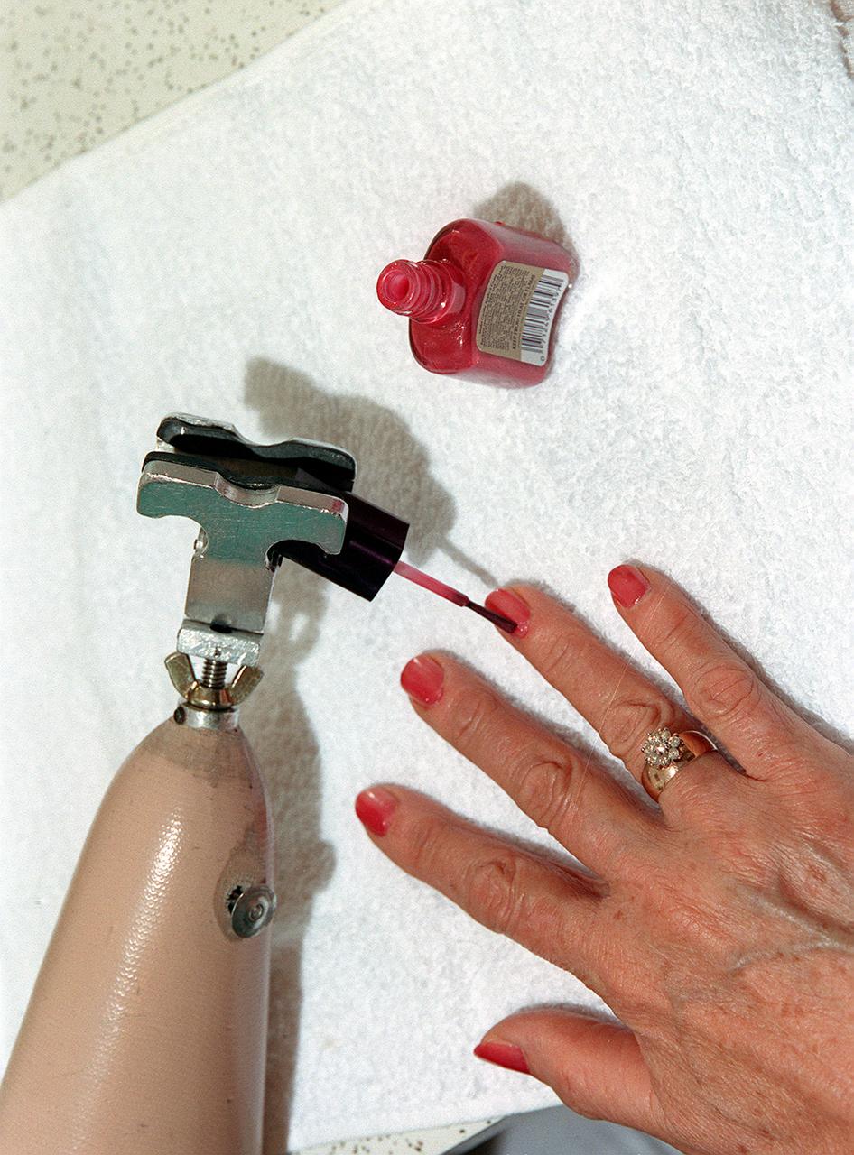 In this photograph, Amputee Amie Bradly uses a NASA-developed prosthesis to paint her fingernails. Derived from foam insulation technology used to protect the Space Shuttle External Tank from excessive heat, FAB/CAD, a subsidiary of the Harshberger Prosthetic and Orthotic Center, utilized the technology to replace the heavy, fragile plaster they used to produce master molds for prosthetics. The new material was lighter, cheaper and easier to manufacture than plaster, resulting in lower costs to the customer.