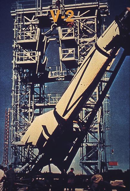 A V-2 rocket is hoisted into a static test facility at White Sands, New Mexico. The German engineers and scientists who developed the V-2 came to the United States at the end of World War II and continued rocket testing under the direction of the U. S. Army, launching more than sixty V-2s.