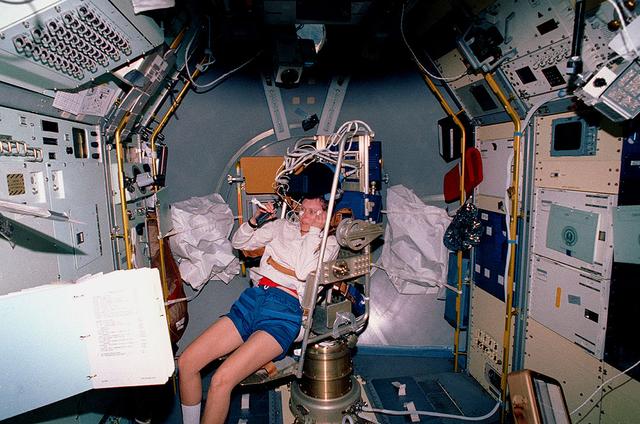 This Space Shuttle Orbiter Discovery (STS-42) onboard photo shows Canadian Payload Specialist Roberta Bondar getting into the Microgravity Vestibular Investigation (MVI) chair to begin an experiment in the International Microgravity Lab-1 (IML-1) Science Module. The (MVI) chair was designed to test the crew member's visual and vestibular responses to head and body movements.